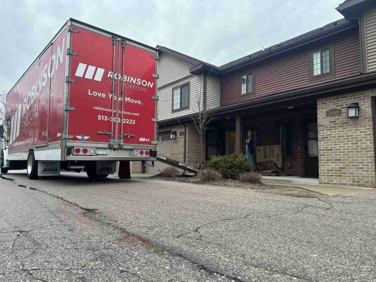 Moving truck with its ramp down outside a brick townhome during a Cincinnati home move