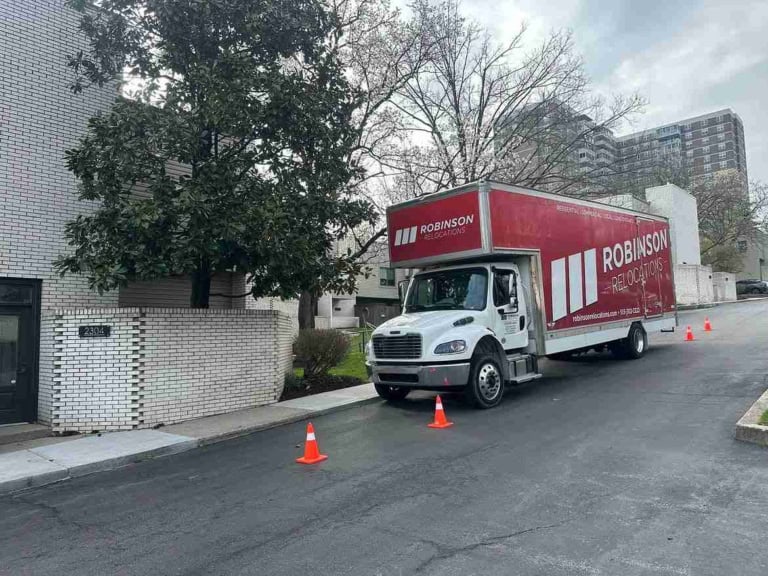 Moving truck parked with safety cones outside a Cincinnati apartment building